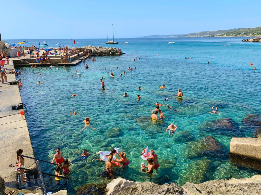 Castro. A small Salento seaside town with a picturesque harbor. A public beach with rocky shelves and concrete piers, popular with locals and visitors all summer long. Photo copyright ©️ the Puglia Guys.