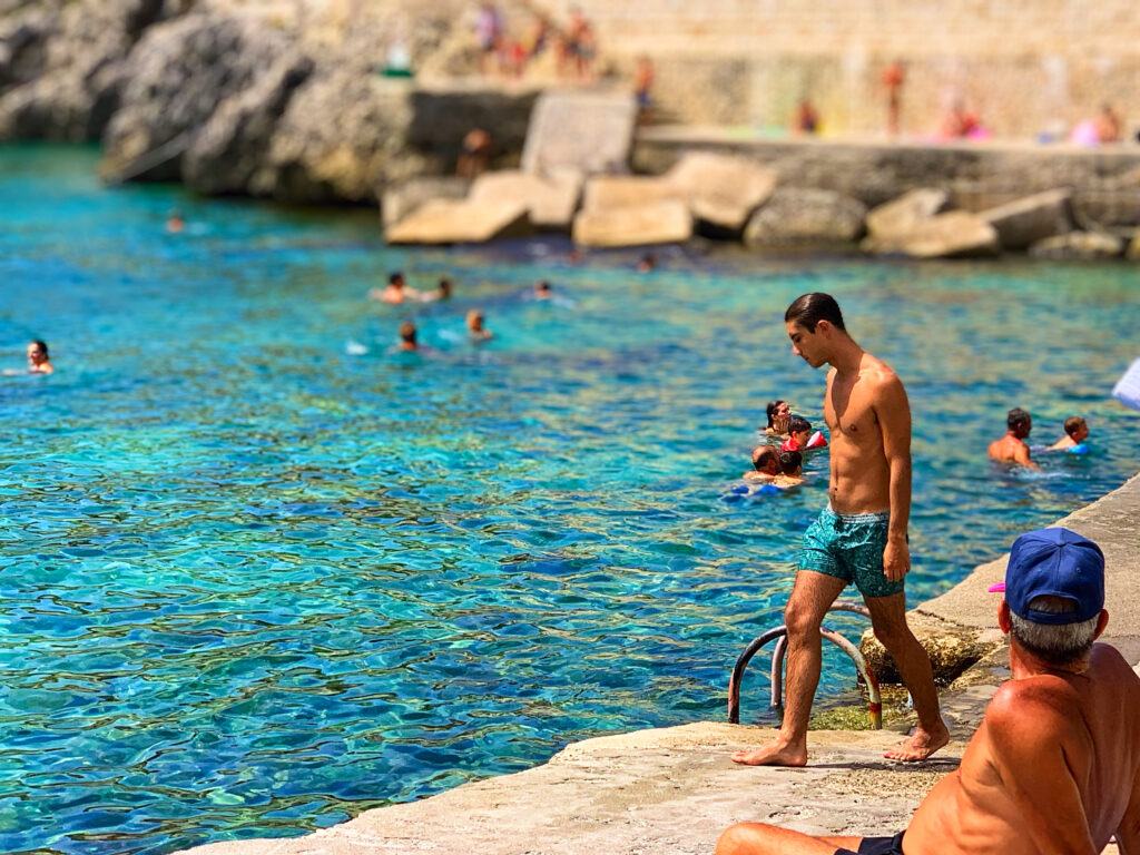 Castro. A small Salento seaside town with a picturesque harbor. A public beach with rocky shelves and concrete piers, popular with locals and visitors all summer long. Photo copyright ©️ the Puglia Guys.